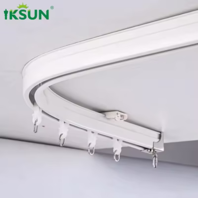 White aluminum curved track installed on ceiling close-up with rollers and hooks.